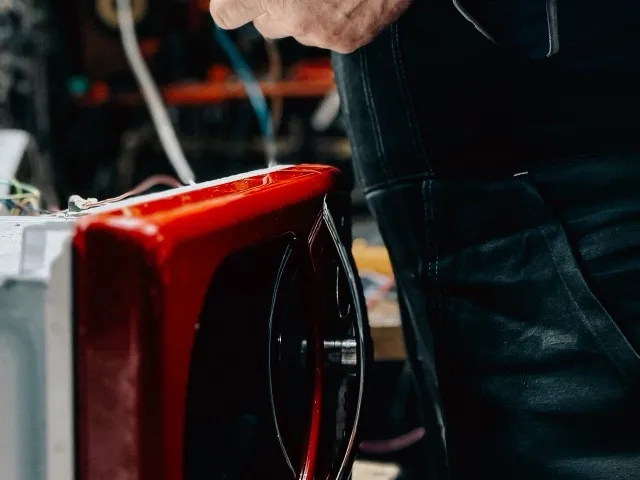 Szakember elektromos háztartási kisgép vezérlőelektronikáját ellenőrzi